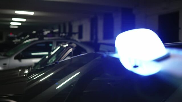 racking focus to an old vintage car with TAXI sign on top. Parking garage building.