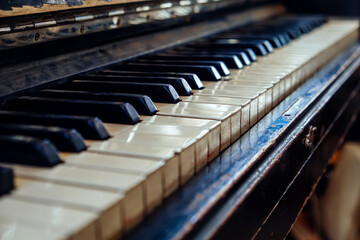 Close-up of black and white keys of an old wooden piano. Vintage piano keyboard, selective focus, bokeh.