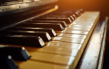 Close-up of black and white keys of an old wooden piano. Vintage piano keyboard, selective focus, bokeh.