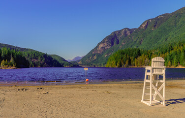 Pre-season lifeguard chair on beach at scenic Buntzen Lake, BC, with spectacular mountain backdrop.