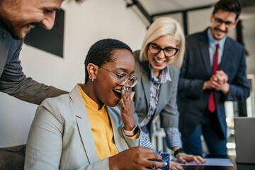 The team celebrated a female colleague's birthday in the office during a meeting. Focus on a black...