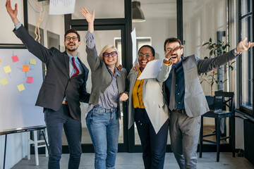 Four female and male Caucasian businesspeople wearing a formal suit, working together with...