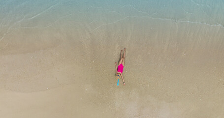Aerial view with Tourism, travel and vacation in a luxury resort. Woman in  pink bikini on the beach of the seashore