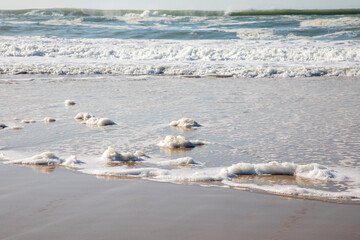 scum sea water soft ocean wave on the sandy beach background