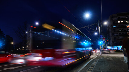 Long exposure shot of bus riding on city street. Traffic on evening city streets blurred motion...