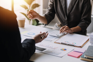 Financial analysts analyze business financial reports on a digital tablet planning investment project during a discussion at a meeting of corporate showing the results of their successful teamwork.