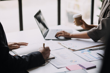 Financial analysts analyze business financial reports on a digital tablet planning investment project during a discussion at a meeting of corporate showing the results of their successful teamwork.