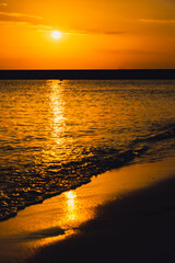 Reflection of sunlight over sea surface at sunset. Orange and gold blue sky. Scenic Gold sea....