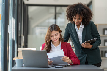 Fototapeta premium Young Asian and African businesswoman Africans brainstorming on real estate projects. investment plan Financial business together in the office management concept management.
