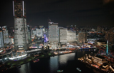 Fototapeta na wymiar Night view of modern skyscrapers illuminated in Japan Yokohama Port City