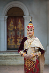 Obraz premium Pretty young Asian woman dressed elegantly in dress Luang Prabang Laos style for the Songkran Festival is the national tradition of Thailand and in Vientiane Laos at Chiang Mai Thailand.