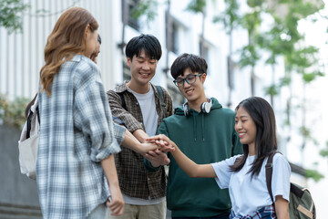 Group of happy multiethnic colleagues shaking hands Express joy in the creative team. Friends or students in project meetings at modern university startups or teamwork concepts.