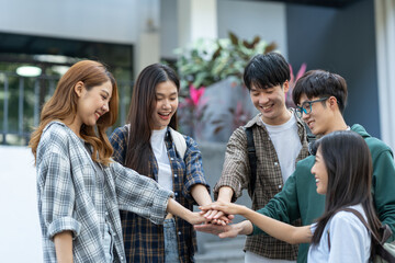 Group of happy multiethnic colleagues shaking hands Express joy in the creative team. Friends or students in project meetings at modern university startups or teamwork concepts.