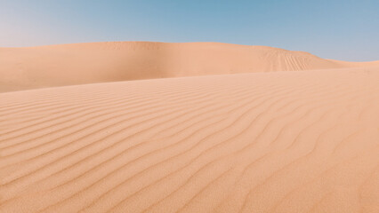 Sand dunes in the desert with a light on the top