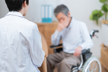 Fototapeta na wymiar 医者と話す高齢の患者（車椅子・介護）
