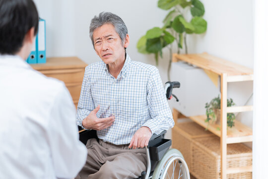 医者と話す高齢の患者（車椅子・介護）