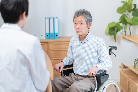 医者と話す高齢の患者（車椅子・介護）