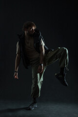 Stylish trendy dancer man in fashion clothes is dancing in the dark. Guy dancer silhouette