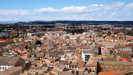 Fototapeta na wymiar Ville du sud e la France avec vue sur les toits des maisons provençales et ruelles étroites et collines boisées en fond.