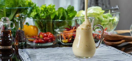 homemade sauces of salad dressings and olive oil in small glass jug including Japanese sesame seed....