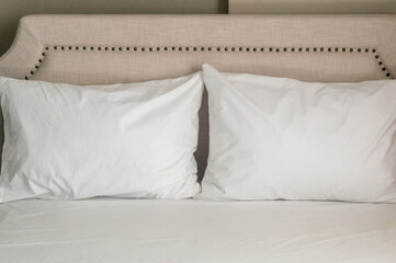Two white pillows on luxurious bed prepared for guest in luxurious resort or hotel room