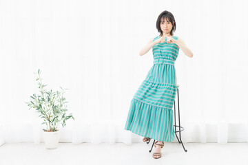 窓際に座ってNGのサインをする若い女性