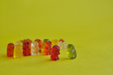 delicious gummy bears on yellow background