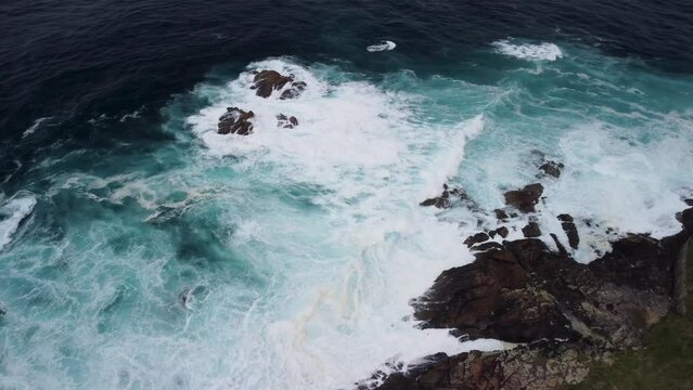 Breaking Waves Onto Rugged Shore With Foamy Surface In Caion Beach, Coruna Spain. Aerial Drone Shot