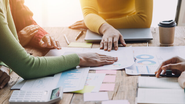 Financial analysts analyze business financial reports on a digital tablet planning investment project during a discussion at a meeting of corporate showing the results of their successful teamwork.