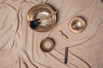Image with several musical Tibetan bowls and a xylophone lying on a soft wrinkled plaid. Ancient...