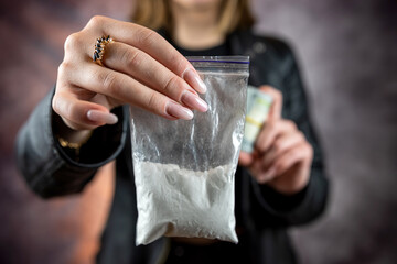 Packet with cocaine narcotic powder in female dealer, crime concept