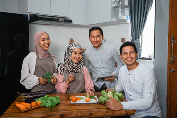 portrait of smiling friend together preparing for iftar dinner in the kitchen