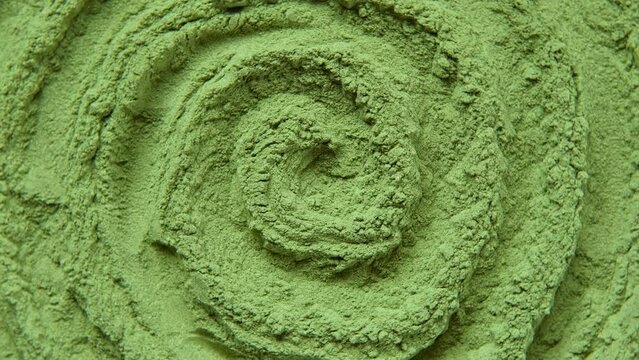 Chlorella or spirulina algae green powder is spinning, rotation. Dietary supplement to improve health. Seaweed superfood. Healthy food background. Vitamins and minerals to diet. Detox. Close up video.