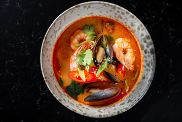 pan asian food. Tom Yum soup in bowl on table background