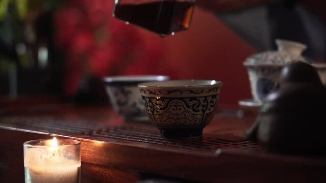 hot drink, young woman conducts a tea ceremony and pours traditional puero into bowls on a table with tea accessories, close-up