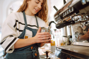 Female barista making coffee in a coffee machine. Conception of business and service. Takeaway food.