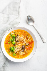 Tomato egg drop soup  with mushrooms and spring onions in a white bowl