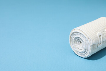 Concept of help during an injury, elastic bandage on blue background