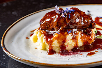 Stewed veal cheeks with mashed potatoes on plate