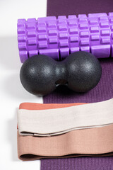 Fototapeta na wymiar Sports equipment - massage roller, back ball and fabric fitness bands.