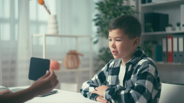 Child psychologist showing cards to little boy, critical thinking assessment
