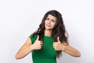 Close-up portrait of attractive surprised girl, showing thumbs up gesture. Success luck concept.