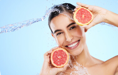 Grapefruit, water or happy girl portrait with beauty in studio on blue background for healthcare or natural diet. Smile, wellness or healthy model face with fruits or vitamin c for skincare or detox