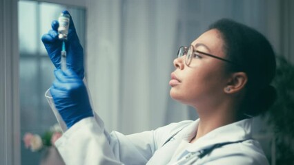 Female lab scientist preparing syringe with covid medicine for testing, research