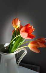 Bunch of tulips in the jug. Selective focus 