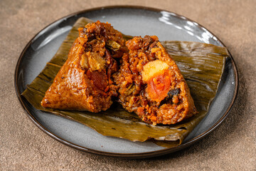 Zongzi is a traditional Chinese food made of glutinous rice stuffed with different fillings and wrapped in bamboo reed, or other large flat leaves. They are cooked by steaming or boiling.