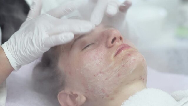 Close-up of professional facial skin care treatment with a cosmetic steamer for skin cleaning at beauty salon.