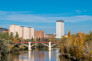 Fototapeta na wymiar Valladolid city - Spain. View of River Pisuerga and Alfonso Suarez Bridge. Travel destination in Spain. Autumn landscape