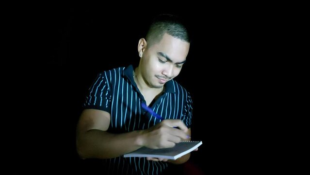 handsome young filipino man writing