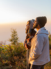 young couple enjoying the sunrise in the meadow